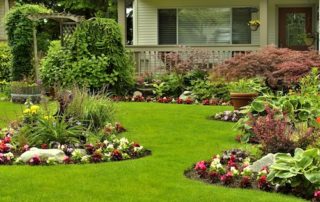 Beautifully landscaped yard with rocks, flowers and grass.